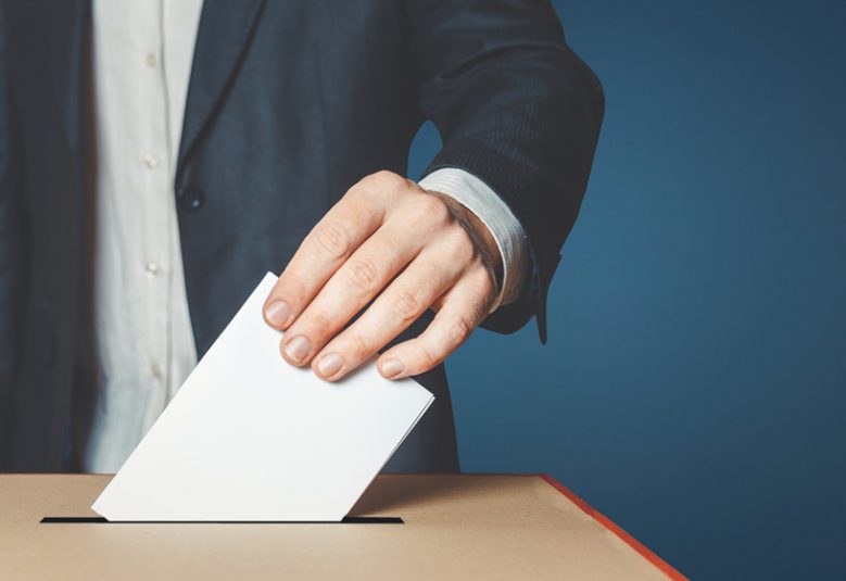 man placing ballot in box