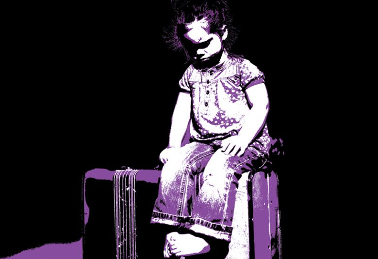 Child sits on a suitcase