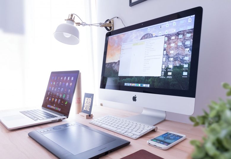 Computer, laptop and mobile phone on a desk