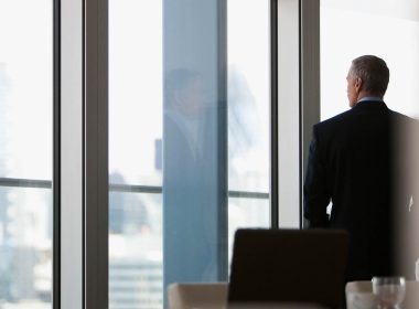 Corporate businessman in a boardroom looking out the window