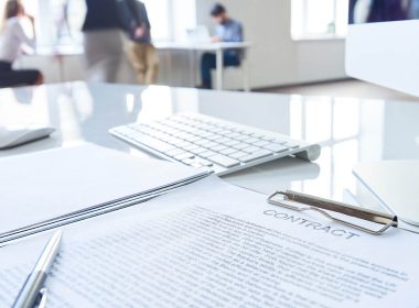 Close up of contract document on a desk with pen awaiting signature