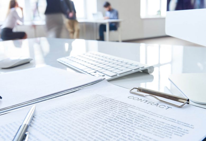 Close up of contract document on a desk with pen awaiting signature