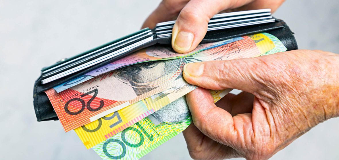 Close up of man's hands holding a wallet with cash and credit cards showing