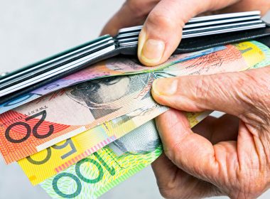 Close up of man's hands holding a wallet with cash and credit cards showing