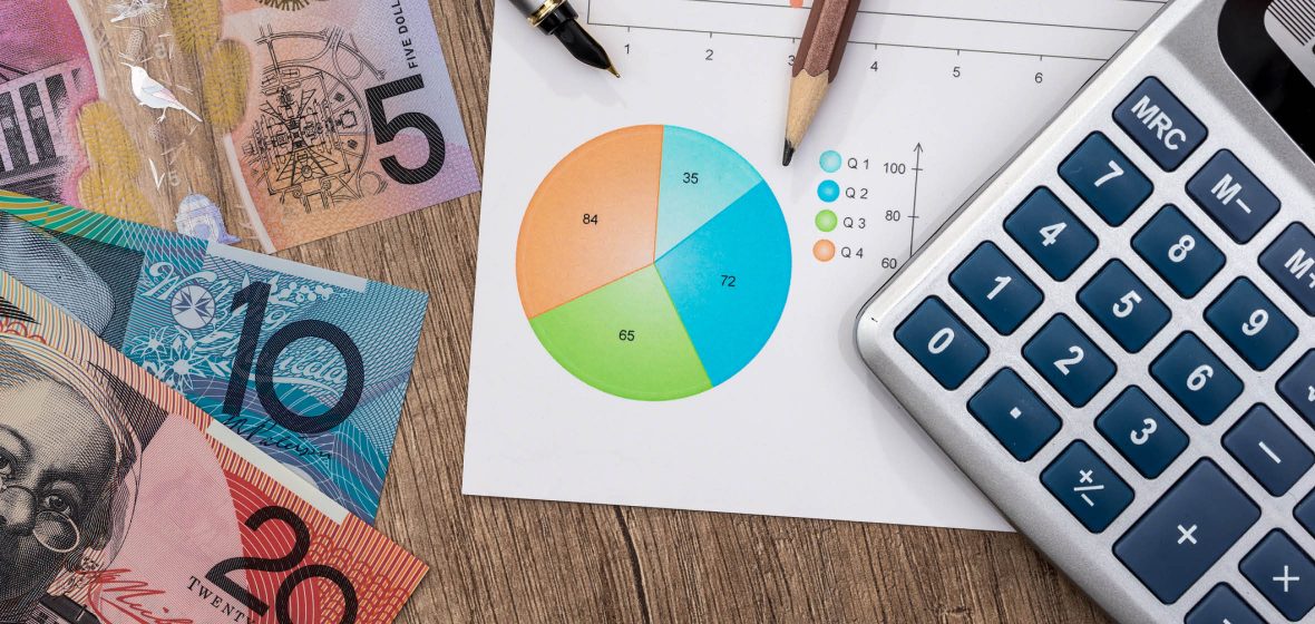 Money, a pie chart and a calculator on a desk