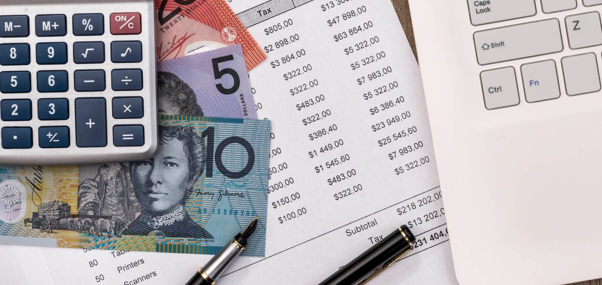 calculator, money and bank statement next to a laptop on a desk