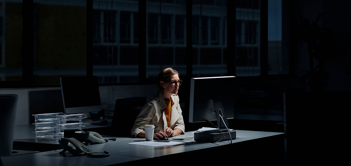 woman using a computer in a dark office