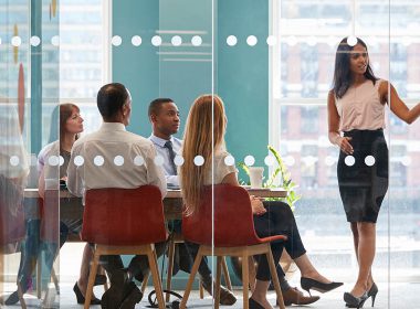 woman gives presentation to group in a boardroom