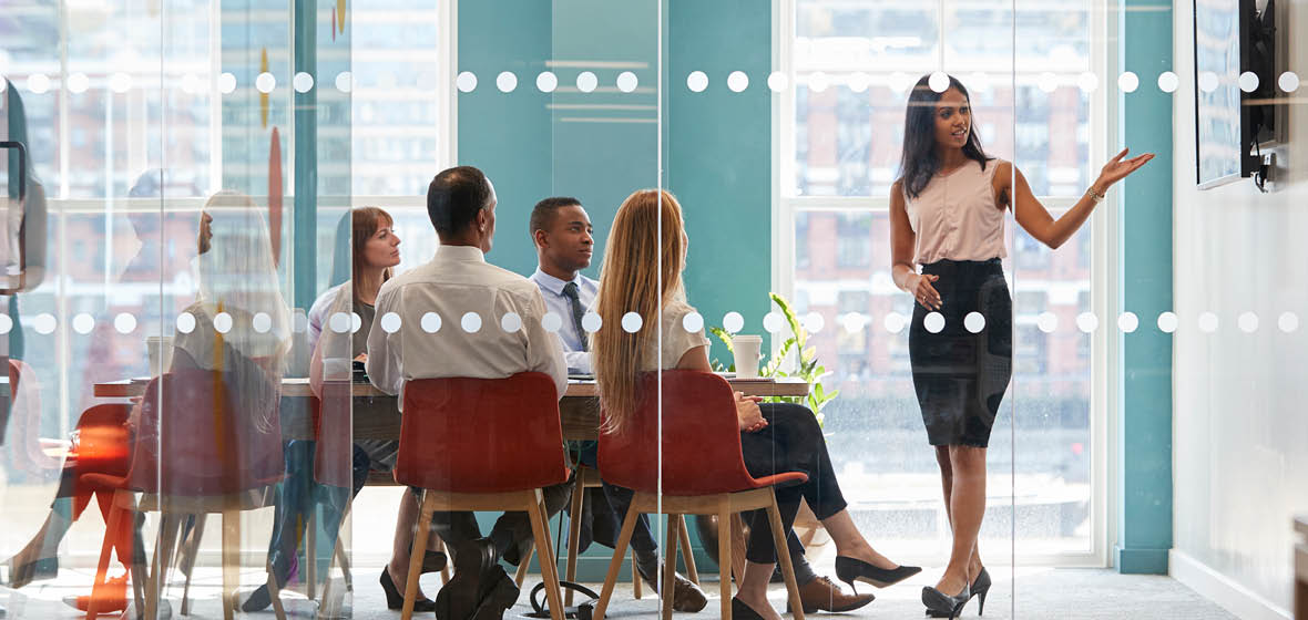 woman gives presentation to group in a boardroom