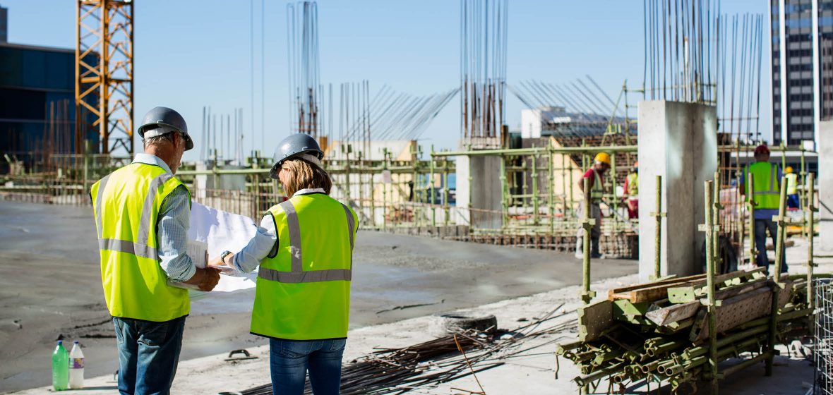 Construction workers consult plans on a building site