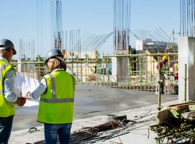 Construction workers consult plans on a building site