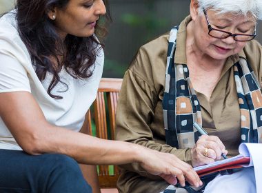 Solicitor reviews document with older female client