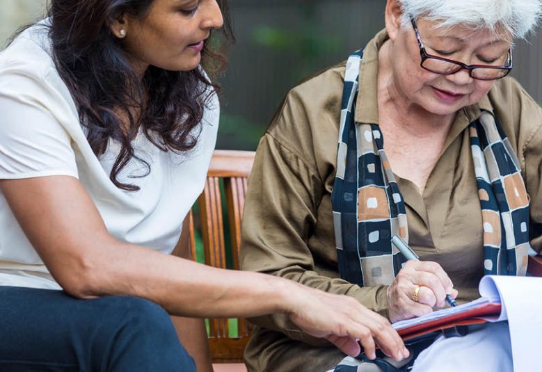 Solicitor reviews document with older female client