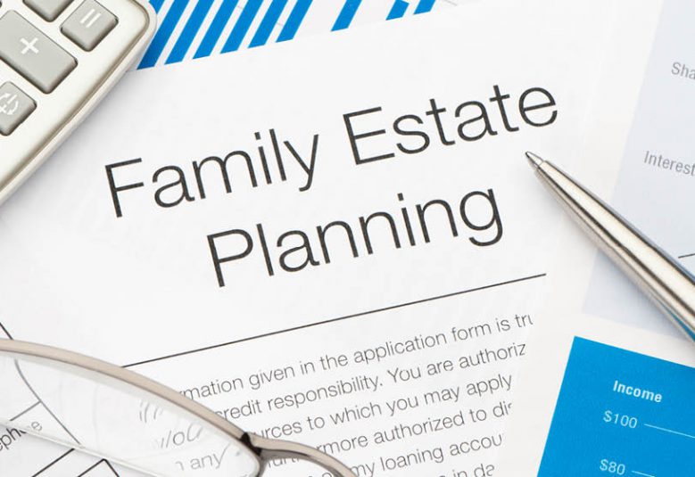 A family estate planning document on a desk with a calculator, pen and eyeglasses