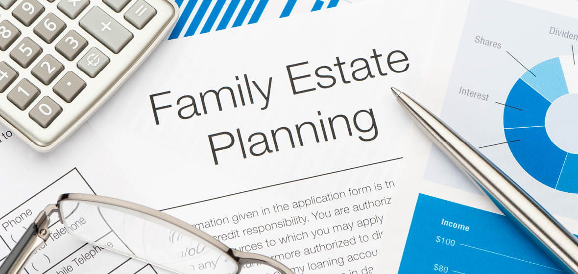 A family estate planning document on a desk with a calculator, pen and eyeglasses
