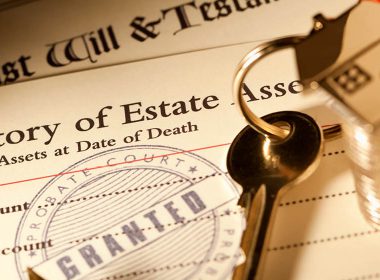 Stack of probate and will documents on a desk with a set of keys and coins