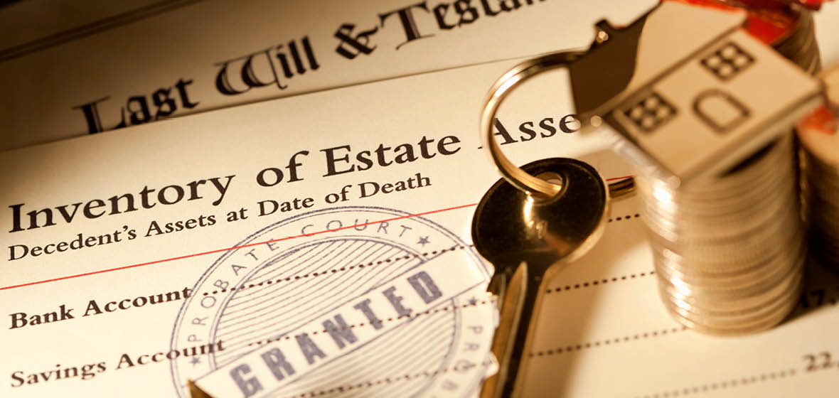 Stack of probate and will documents on a desk with a set of keys and coins