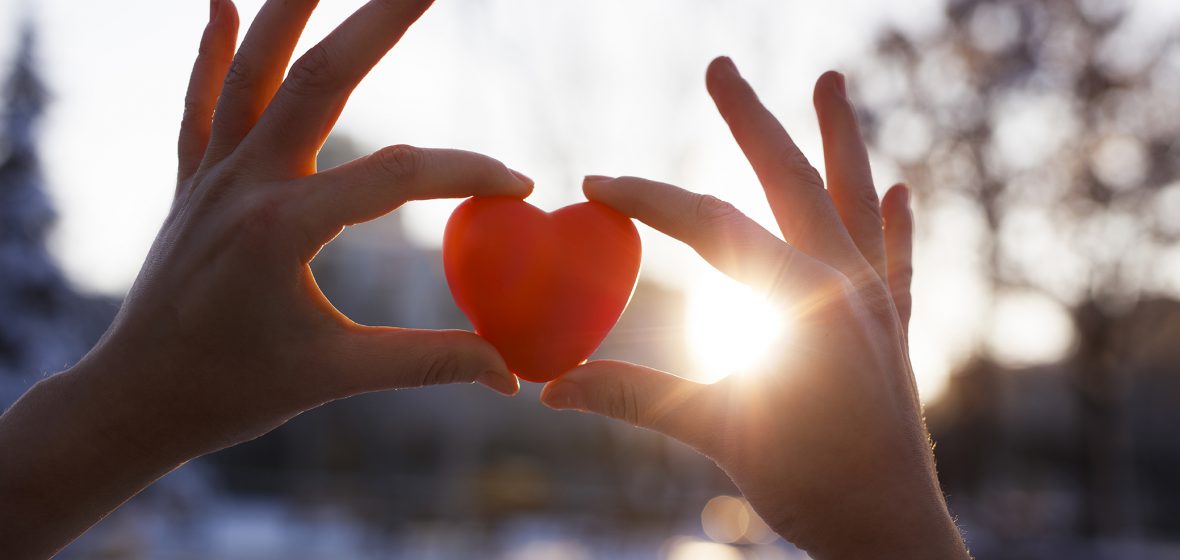 Woman holding heart-shaped snowball