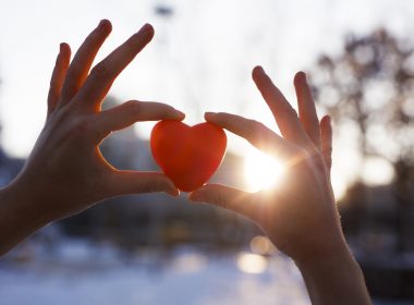 Woman holding heart-shaped snowball