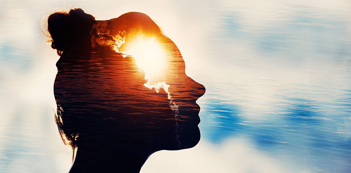 Silhouette of young woman on sky background with sun in her head.