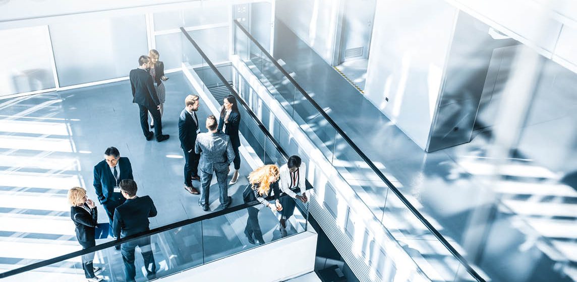 Colleagues networking in an open plan area of an office