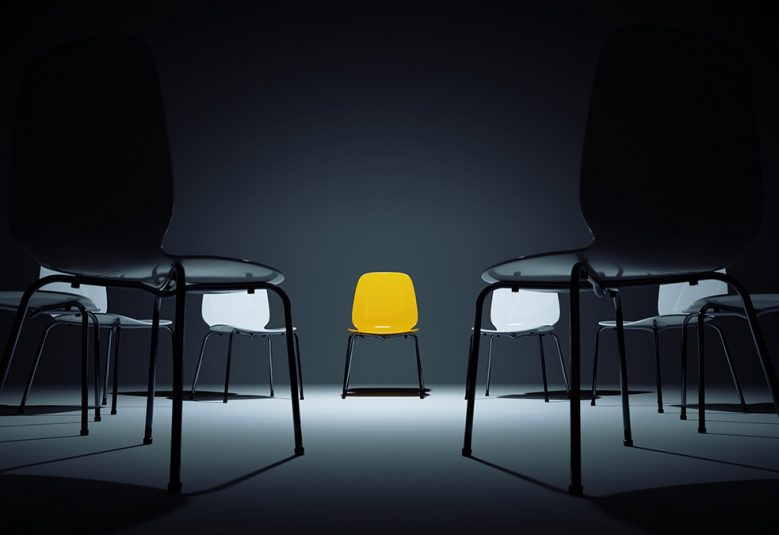Circle of white chairs. One is yellow.
