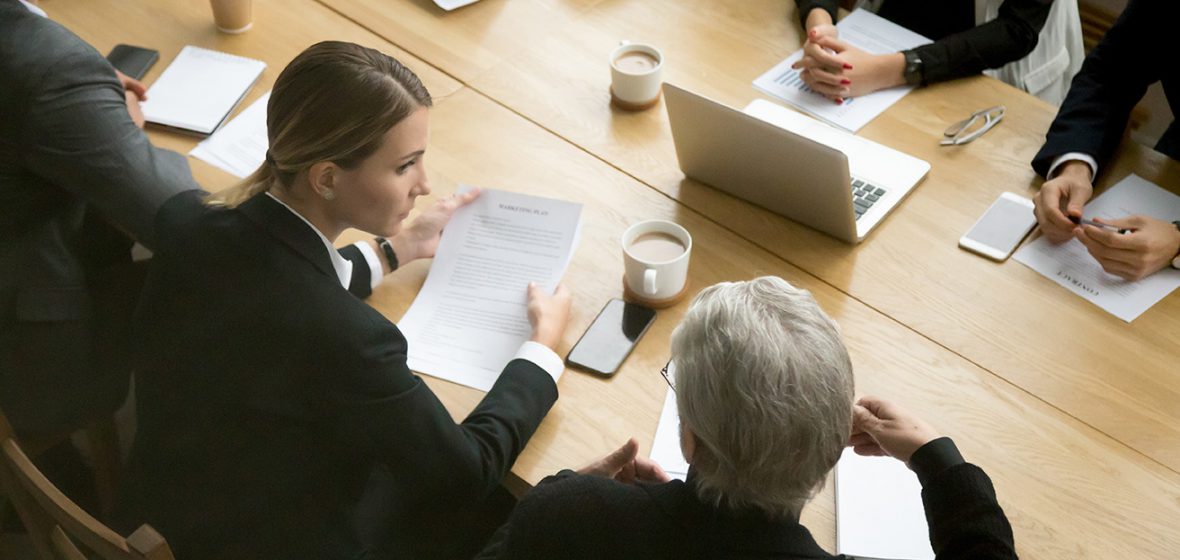 team of solicitors sitting at a table reviewing documents