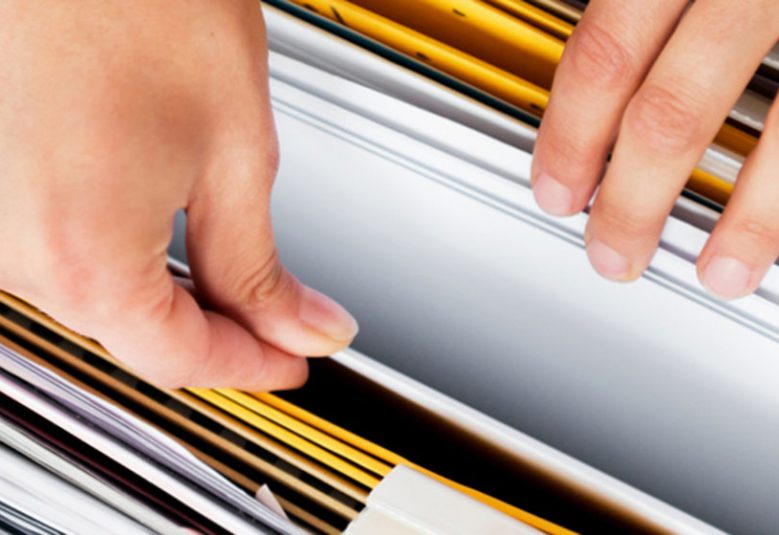 woman's hands going through filing cabinet