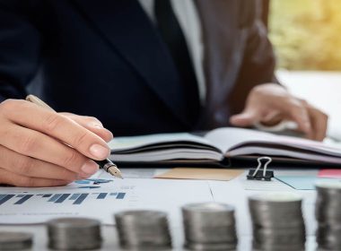 man writing on a financial chart