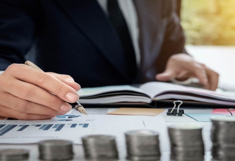 man writing on a financial chart