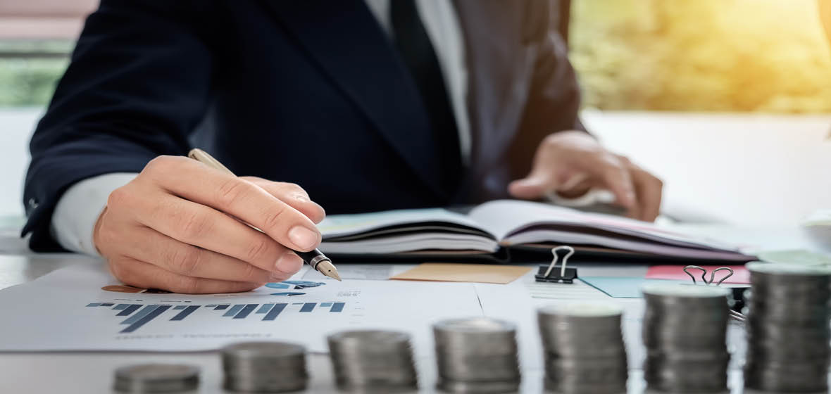 man writing on a financial chart