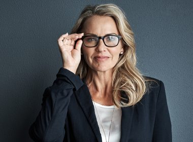 Professional woman holding reading glasses