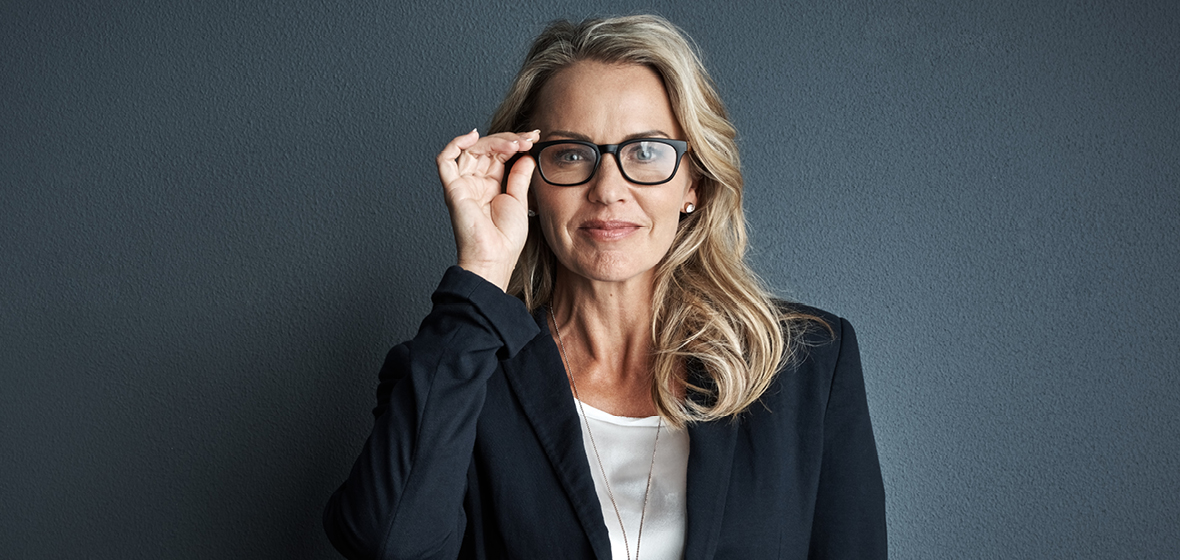 Professional woman holding reading glasses