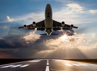 Passenger airplane taking off at sunset