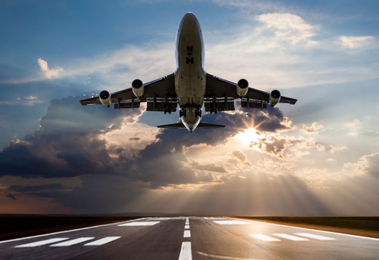 Passenger airplane taking off at sunset