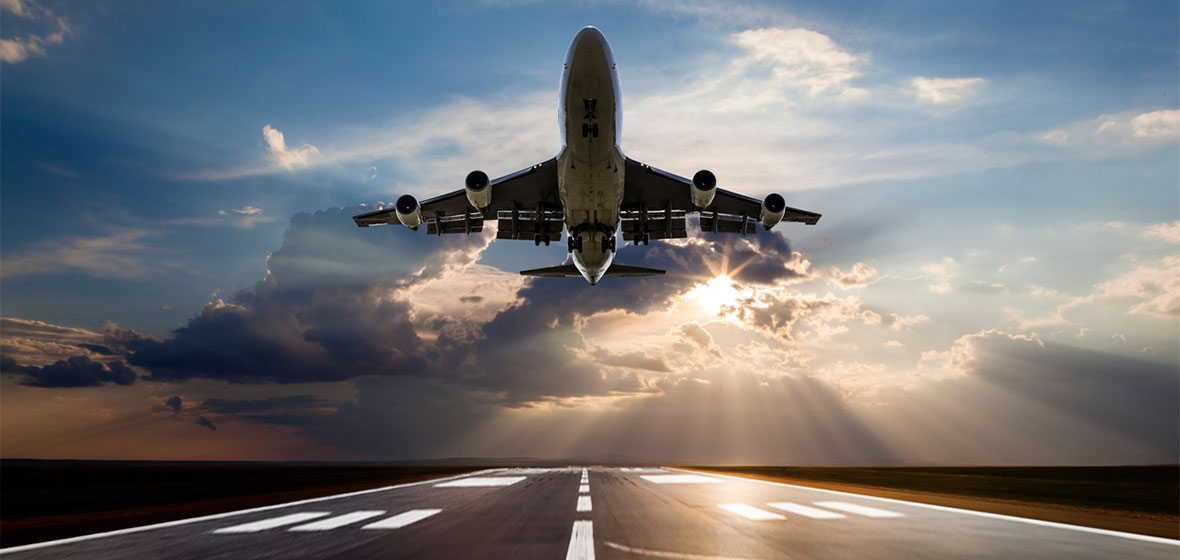 Passenger airplane taking off at sunset