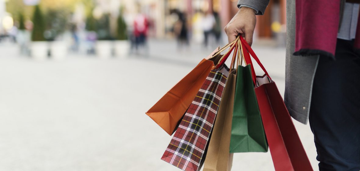 Man holding shopping bags with presents on the street