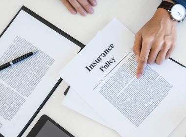 A man reviews insurance policy documents on a desk