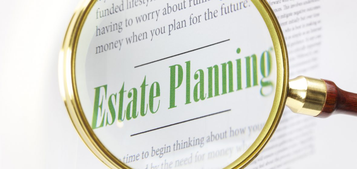 A magnifying glass focused on the words 'Estate Planning'