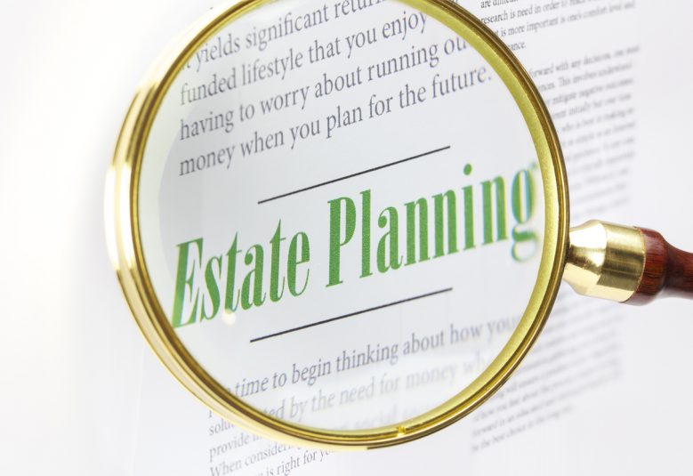 A magnifying glass focused on the words 'Estate Planning'