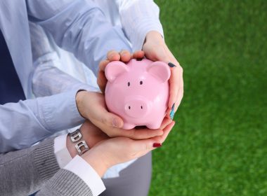 Two people holding a piggy bank