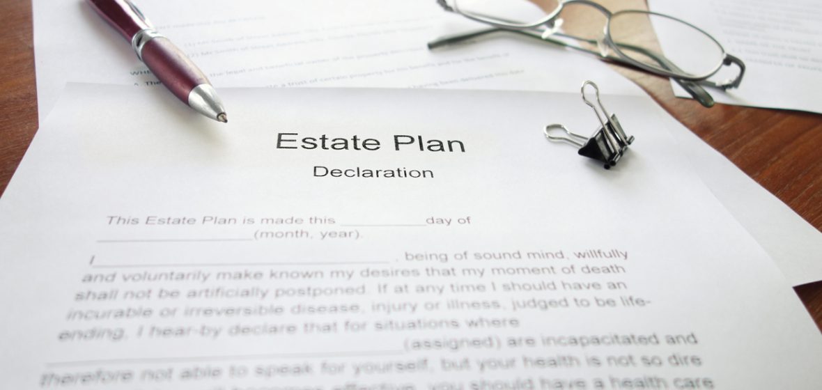 An Estate Plan document on a desk with pen and glasses