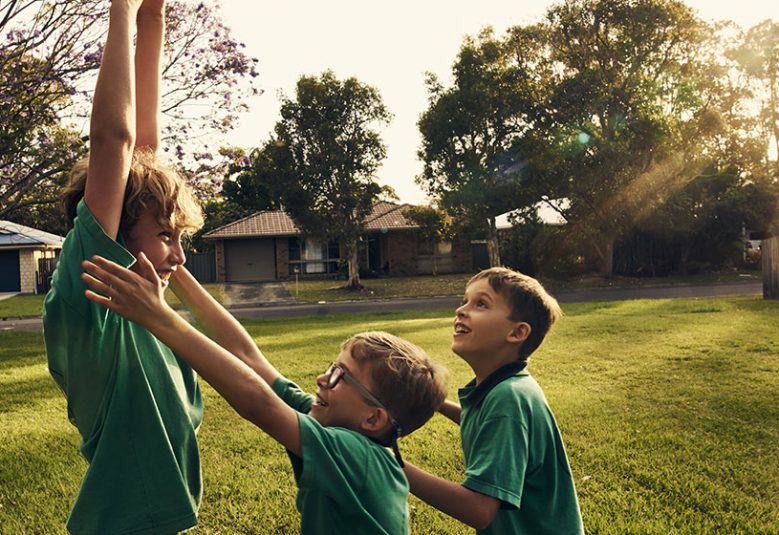 Two brothers play in a backyard