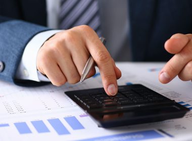 Man uses calculator at a desk