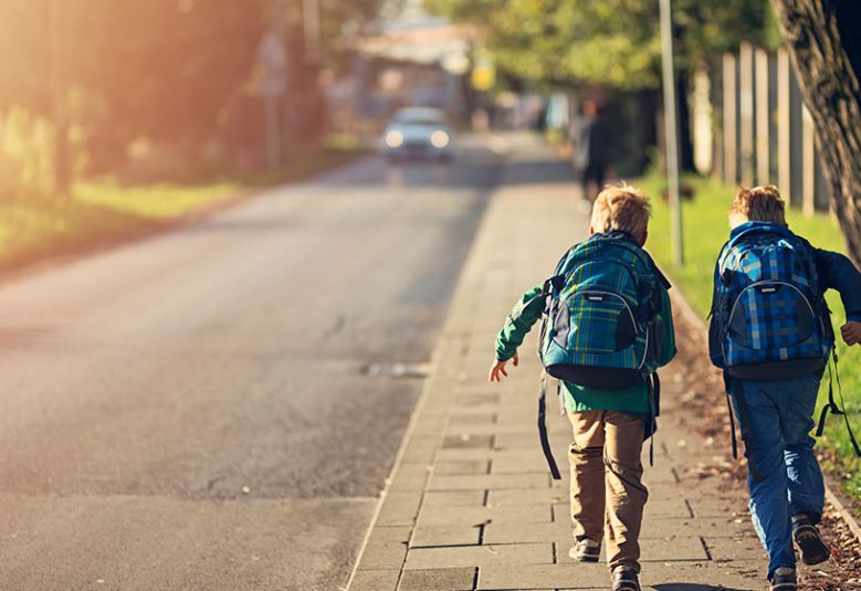 Two school children run up a footpath