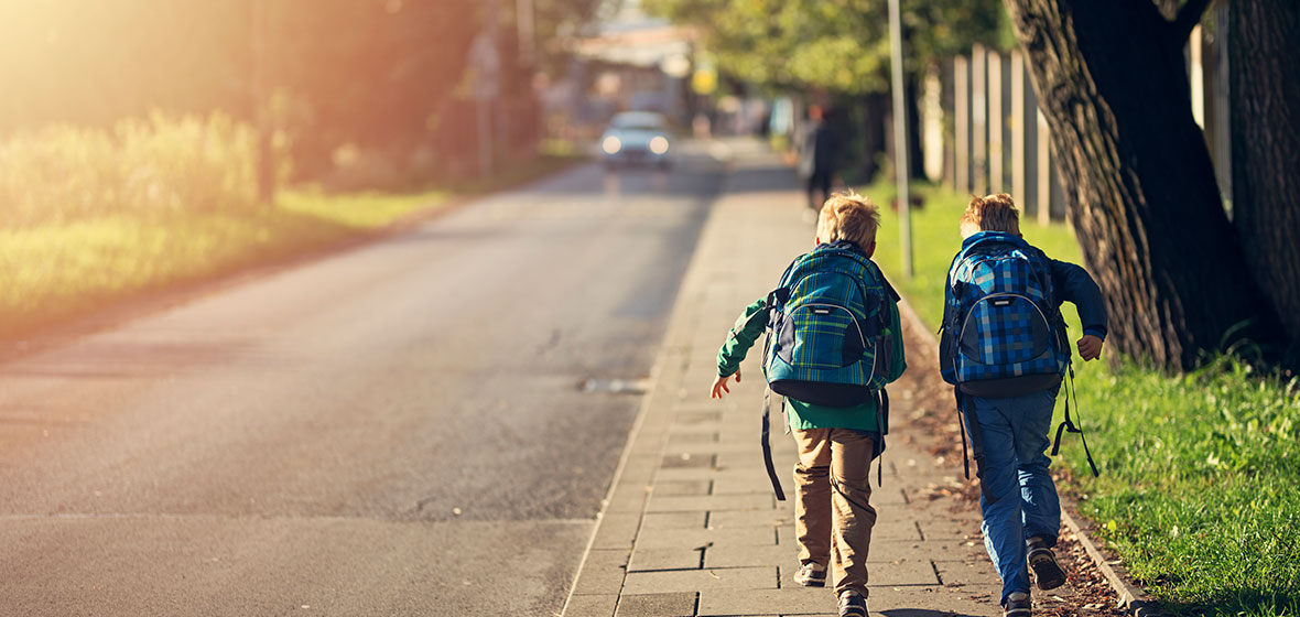 Two school children run up a footpath