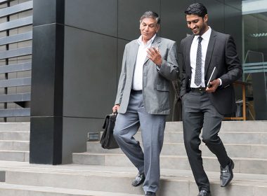 Two men walk down stairs outside a building