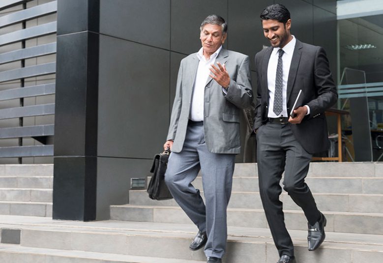 Two men walk down stairs outside a building