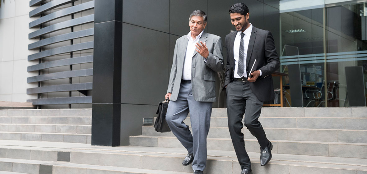 Two men walk down stairs outside a building