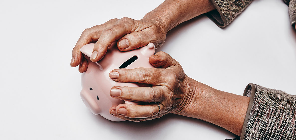 Older woman holds a piggy bank